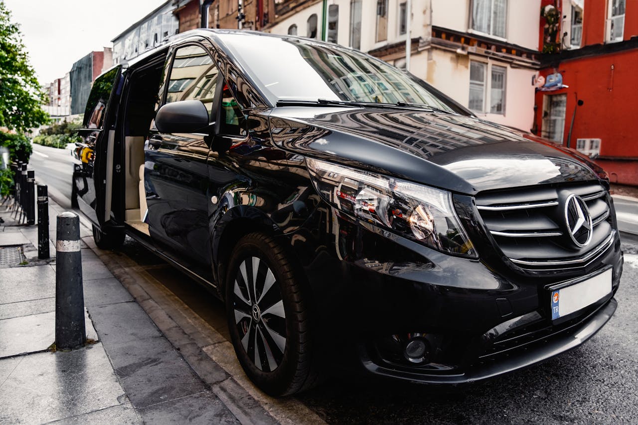 hero-gallery-04 A stylish black Mercedes-Benz van parked on a bustling city street, showcasing luxury and modern design.
