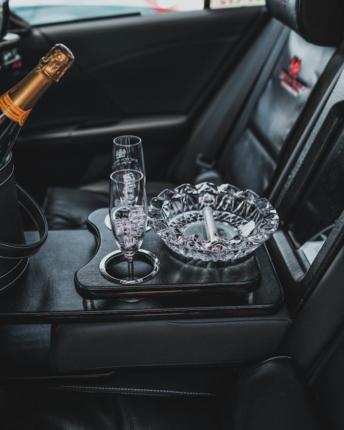gallery-img-05 Elegant car interior featuring champagne bottle, glasses, and ashtray set.